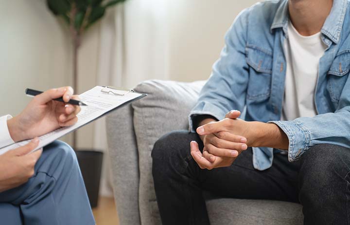 Close-up of psychologist explaining autism assessment report to adult client